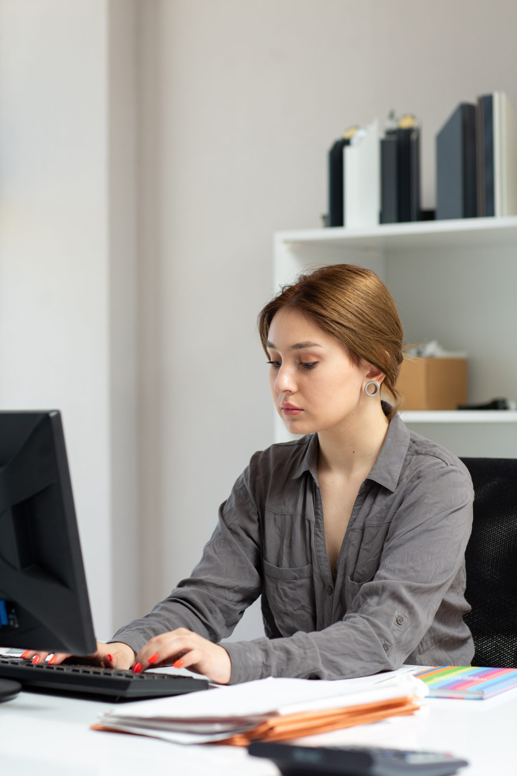 front view young beautiful lady grey shirt working with documents using her pc sitting inside her office daytime building job activity