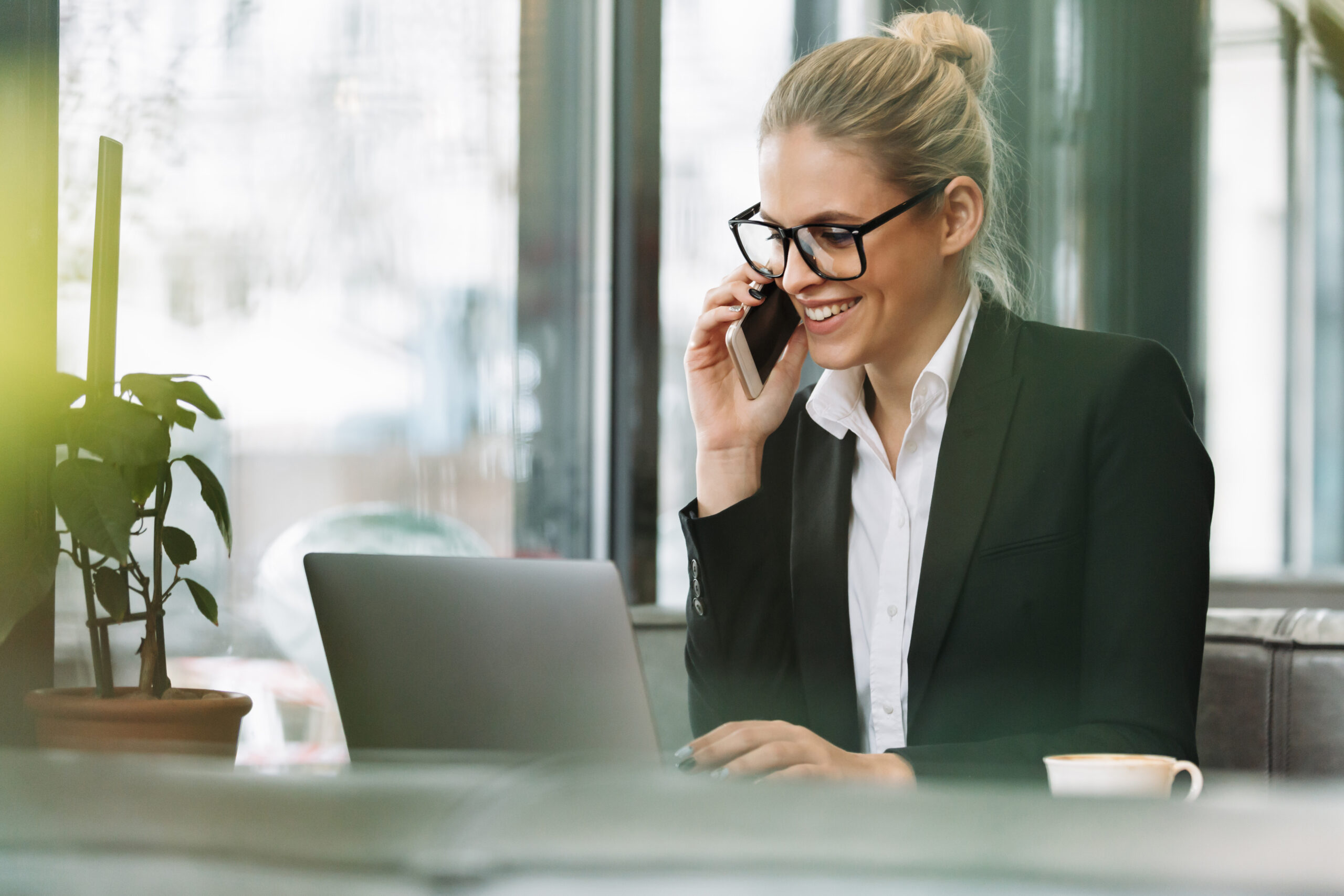smiling blonde business woman talking by mobile phone