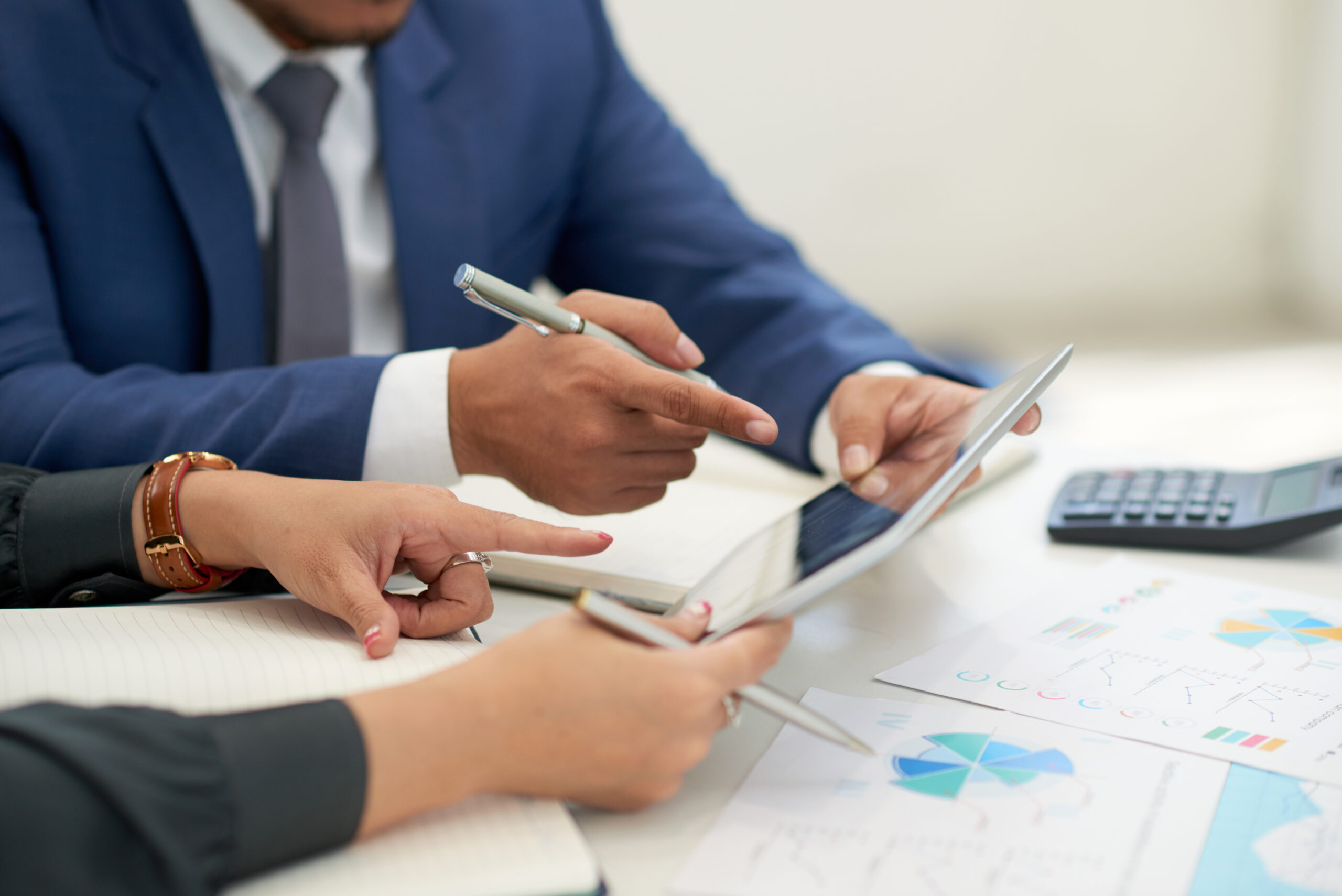 unrecognizable business people sitting meeting with charts looking pointing tablet